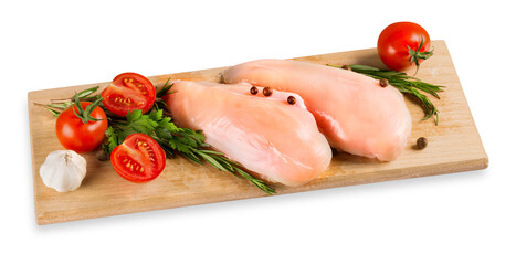 Raw turkey breasts with vegetables, spice and herbs on wooden cutting boardRaw turkey breast with tomatoes and garlic on cutting board