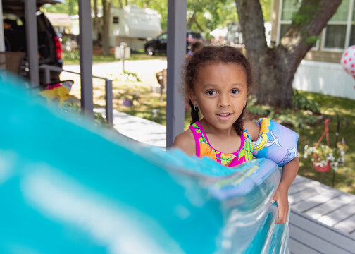 Child Holding A Large Inflated Pool Mattress