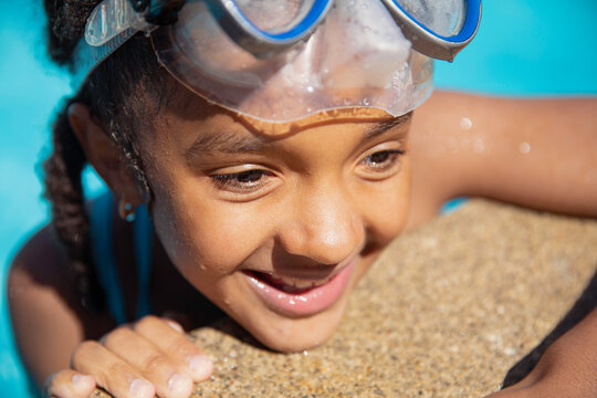 Child leaning against the concrete edge of a pool