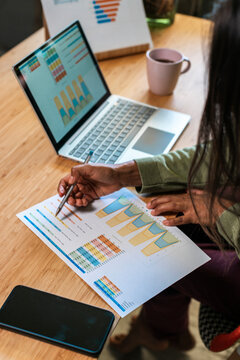 Hispanic woman coworking and analyzing charts