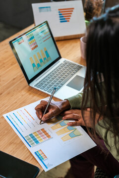Hispanic woman coworking and analyzing charts