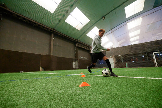 Teenager practicing to on football pitch