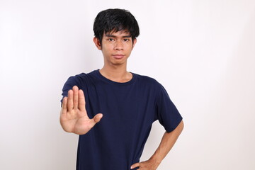 Portrait asian young man standing with stop hand gesture. Isolated on white background