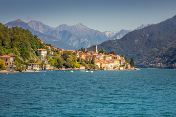 Fototapeta na wymiar Idyllic Lake Como coastline with village and speedboat at sunny day, Italy