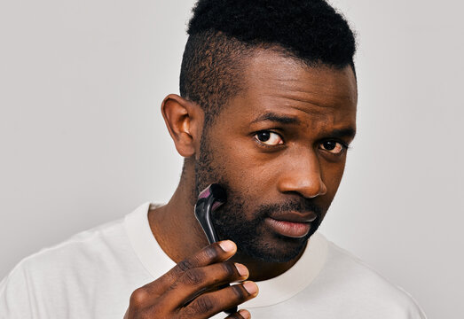Confident man using derma roller