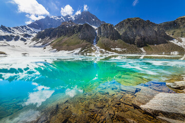 Alpine emerald lake and mountains at springtime, Gran Paradiso Alps, Italy