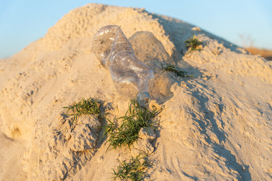 Plastic Bottle, Sand, And Grass.