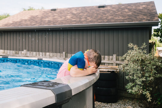Boy adjusting swim goggles in pool