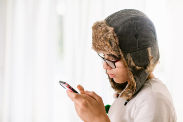 Teen boy with winter beanie using phone