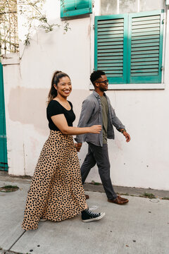 A black couple walking on the sidewalk