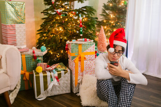Teenager at Christmas using his mobile phone - Powered by Adobe