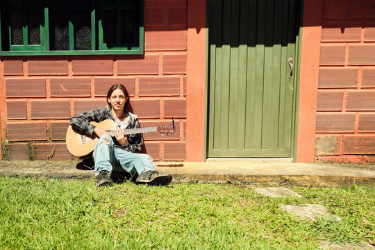 Guitarist sitting on a sidewalk