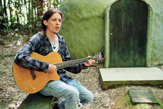 Young man singing while playing his guitar