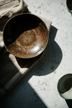 Empty bowls and plates on a table in hard light.