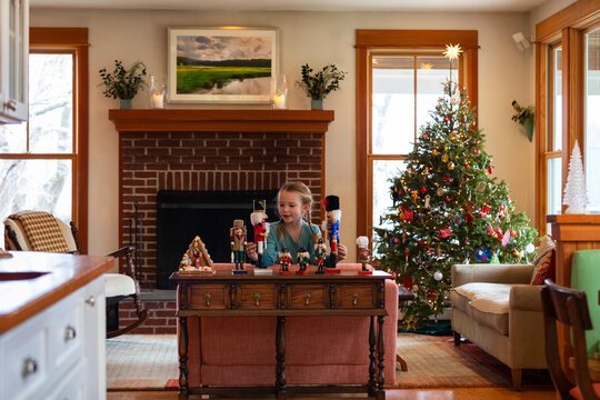Girl plays with Nutcracker Toy in Home during Christmas with Tree  