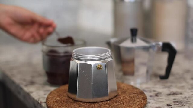 putting coffee into a coffee pot