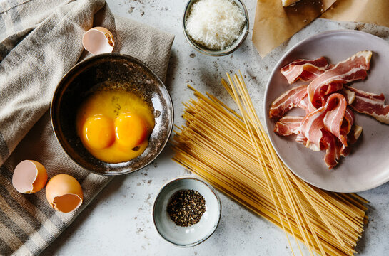 Ingredients for a pasta dish with bacon, egg yolks and parmesan.