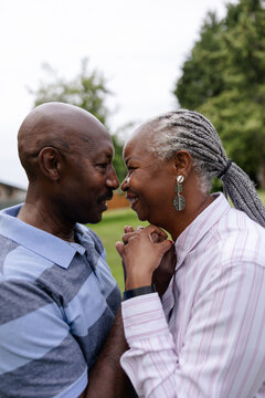 Loving Older Couple Cuddling Together At The Park.