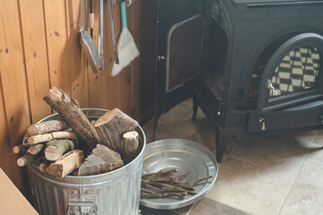 冬の日本の家庭の暖炉と暖炉用の薪と道具、木目調の室内インテリア
