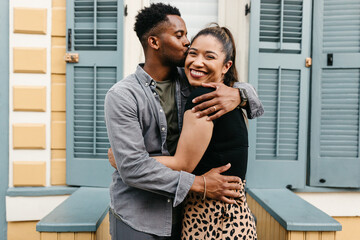 A black couple walking on the sidewalk