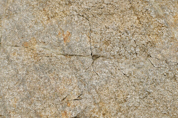 The texture of the rock is made of brown uneven stone covered with cracks