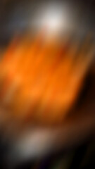 Abstract blurred background with a brownish orange color in the middle.