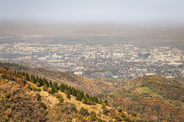 Mountain landscape with a view of the city of Almaty and the visible smog. Almaty air pollution concept