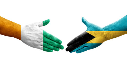 Handshake between Bahamas and Ivory Coast flags painted on hands, isolated transparent image.