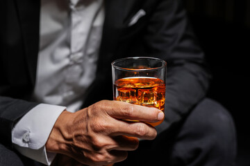Closeup businessmen holding a glass of whiskey