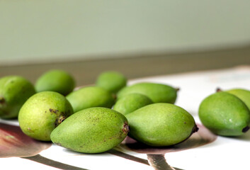 Small green mangoes on a wooden table