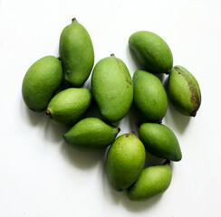 Small green mangoes on a wooden table