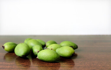 Small green mangoes on a wooden table