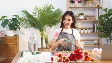 Flower shop concept, Female florist cutting gerbera with scissor to prepare for making flower vase