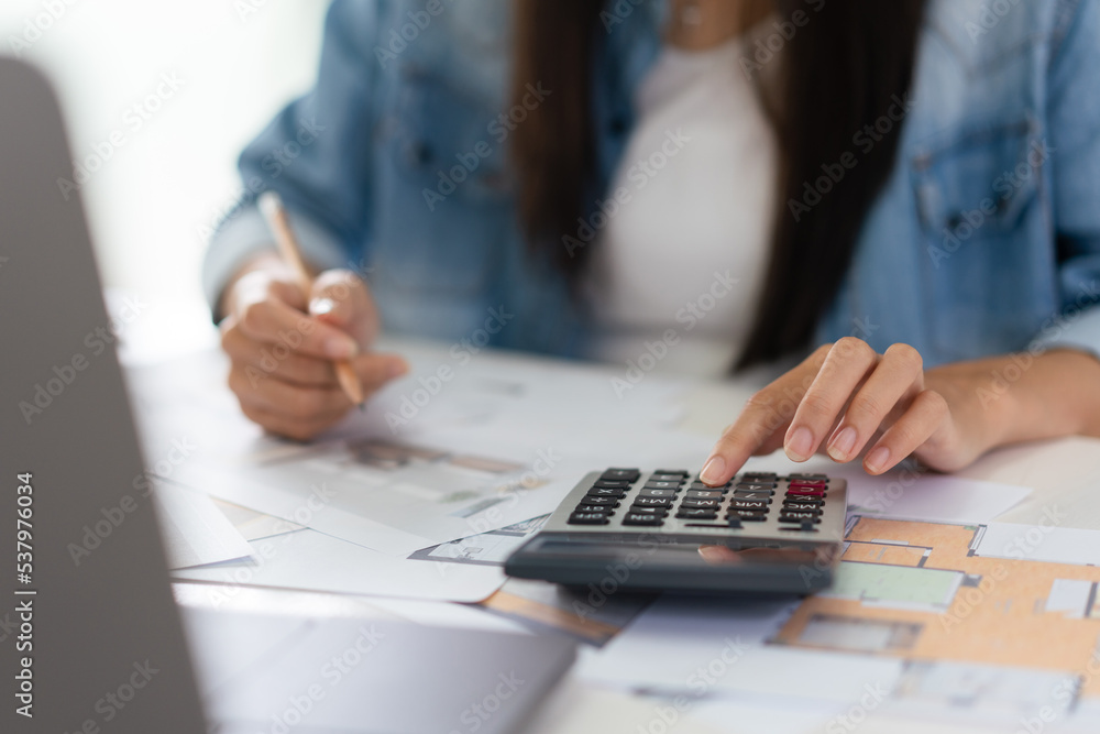Poster design building concept, female architect is using calculator and sketching house plan on blueprint