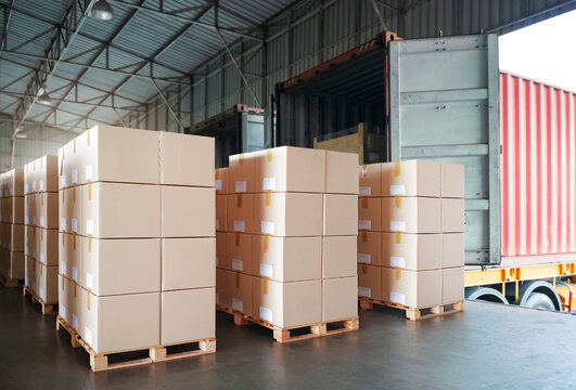 Packaging Boxes Stacked on Pallets Loading into Cargo Container. Delivery Shipping Trucks. Supply Chain Shipment Goods. Distribution Supplies Warehouse. Freight Truck Transport Logistics.	