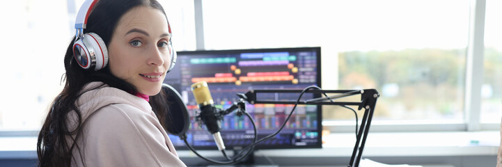 Fototapeta na wymiar Disabled woman works as radio presenter in wheelchair in studio
