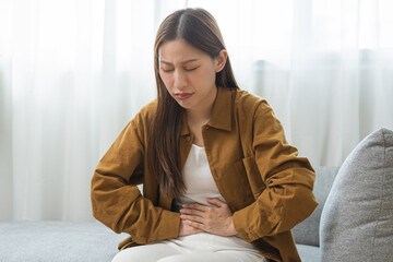 Flatulence asian young woman hand in stomach ache, suffer from food poisoning, abdominal pain and...