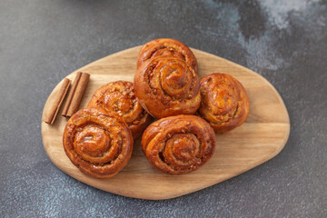 Sweet rolls with cinnamon on wooden board. Caramel buns with nuts.
