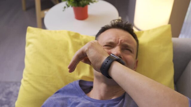 Water dripping from the ceiling drips onto the face of the lying man.
Water dripping from the ceiling of the house drips onto the sleeping man's face.
