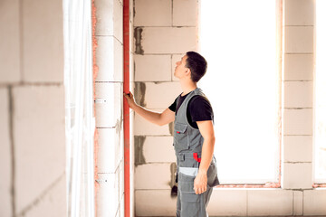 Fototapeta na wymiar male builder at work, building a house, level measurement 