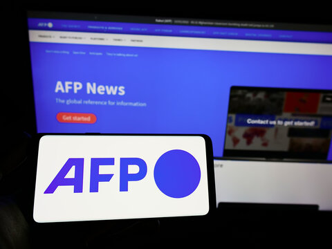 Stuttgart, Germany - 10-03-2022: Person holding smartphone with logo of news agency Agence France-Presse (AFP) on screen in front of website. Focus on phone display.
