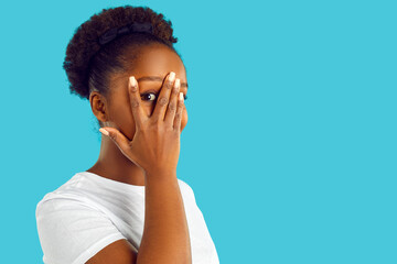 Happy young Afro American woman isolated on blue empty blank advertising copy space background...