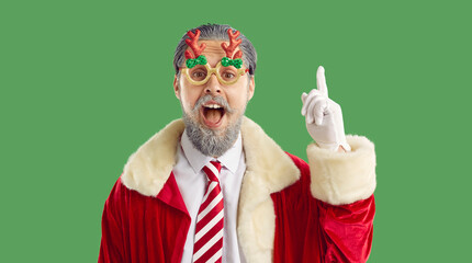 Aha. Happy man with gray beard wearing red Santa costume, striped candy necktie and funny reindeer...