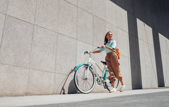 Bike, urban and black woman cycling in the city of Norway for a sustainable lifestyle. Happy, young and smile African girl with a bicycle being eco friendly for her carbon footprint and clean energy