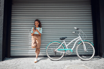 Phone, bicycle and girl on social media in the city searching for cool, funky and trendy online content outdoors. Smile, bike and happy woman texting on a social network for cycling on the internet