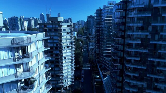 downtown Vancouver laneway homes modern architectural marvel glass high-rises built in 2021-2022 in between older buildings made in 1980s-1990s on a sunny summer fall day aerial drone flyby closeup