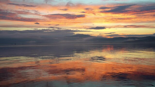 Beautiful nature landscape of orange sunset reflecting in water.