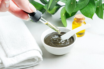 Enreaching black clay homemade mask with essential oil. Spa procedures at home. Skin care concept....