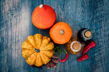 Chili peppers, pumpkins, parsley autumn vegetables on a wooden table. Top view