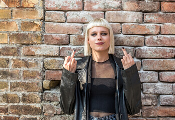 Young beautiful strong independent rebel blonde woman Punk music and style fan posing. Confident Punk-Rock youth culture concept. - obrazy, fototapety, plakaty